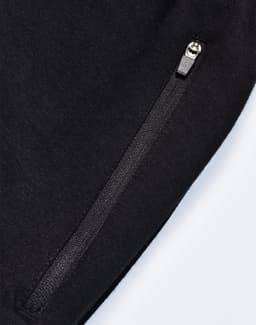 A pair of black poly/cotton terry sweat pants featuring a zip pocket and a soft texture.