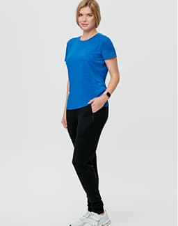 A model wearing black poly/cotton terry sweat pants and a blue top, standing against a plain background.