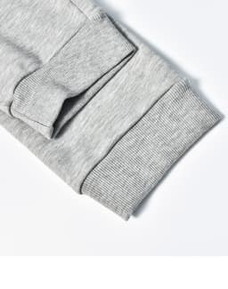 A close-up of grey poly/cotton terry sweat pant cuffs featuring ribbed texture and stitching details.