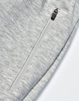 A pair of light grey poly/cotton terry sweat pants featuring a zip pocket.