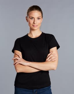 A black cotton semi-fitted tee on a model with arms crossed, against a grey background. The shirt has a logo.