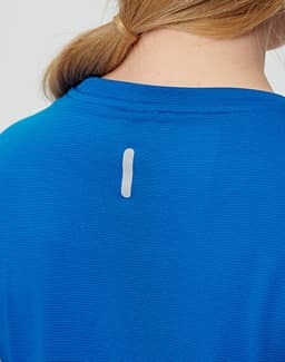 A blue ladies' short-sleeved performance T-shirt featuring a small logo on the back.