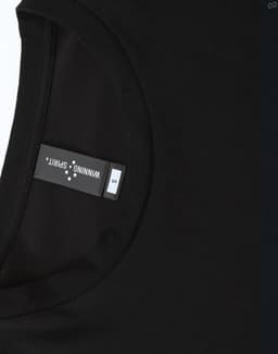 A black men's long-sleeve tee shirt with a rounded neckline and a tag showing sizing information.