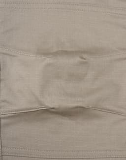 A close-up of unisex cotton stretch ripstop work pants in a light beige colour, featuring a stitched waistband and branding.