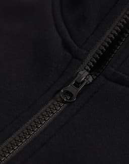 A close-up of a black half-zip collar fleecy jumper featuring a smooth zipper and soft fabric texture.