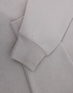A light grey polar fleece jumper featuring a half zip collar and fitted cuffs. It has a subtle logo.