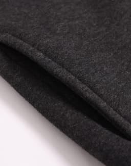 A close-up of a dark grey 1/2 zip collar fleecy jumper, showing the soft texture and stitching details.