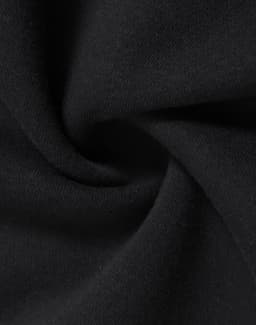 A close-up of black fabric, showcasing a soft, fleecy texture, suitable for a kids' half zip collar sweat.