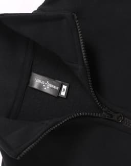 A black fleecy sweatshirt featuring a half zip collar, with an inner label and a subtle logo.