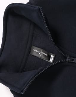 A navy 1/2 zip collar fleecy sweat with a smooth interior and a tag, featuring a logo.