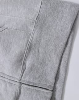 A grey full-zip fleecy hoodie featuring a pocket and a logo. Ideal for casual wear.