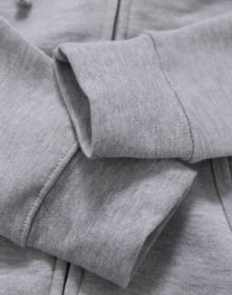 A close-up of a grey ladies' full-zip fleecy hoodie, featuring soft fabric and ribbed cuffs.