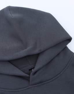 A grey unisex premium fleece oversized hoodie with a large hood, featuring a branding label.