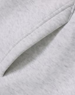 A close-up of a soft, grey fleece fabric featuring a folded edge, showcasing the texture.