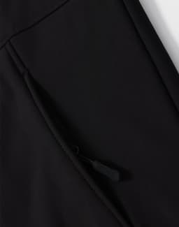 A close-up of a black softshell hoodie with a zippered side pocket and a logo.