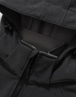 A close-up of the black softshell hoodie with a zippered pocket and a hood. It features a logo on the fabric.