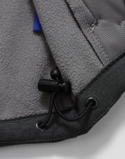 A close-up of the interior of a grey men's softshell full zip hoodie, featuring a drawstring and soft fabric lining.
