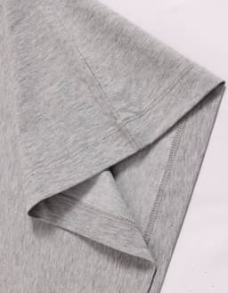 A close-up of a grey long-sleeve cotton tee shirt, featuring a stitched hem and smooth fabric texture.
