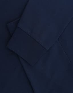A navy blue long-sleeve T-shirt with folded sleeves and a subtle logo.