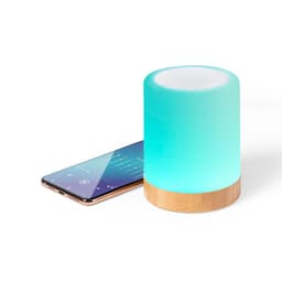 A turquoise Bluetooth speaker with a wooden base beside a smartphone displaying music controls.