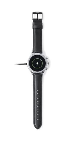 A black smart watch with a round face and silver accents, featuring a charging icon on the display and a logo on the strap.