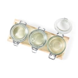 A wooden tray with three glass jars, featuring metal clasps and clear lids. Jars are empty and transparent.