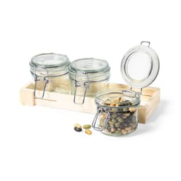 Three glass jars with metal clips, filled with assorted seeds, placed on a wooden tray.