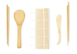 A bamboo sushi set featuring chopsticks, a sushi mat, and sushi serving utensils in natural wood colour.