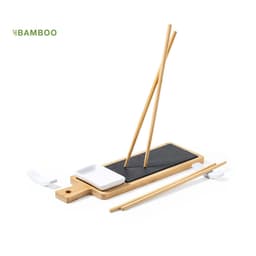 A bamboo sushi set featuring a black plate, white dipping dish, and two pairs of bamboo chopsticks.