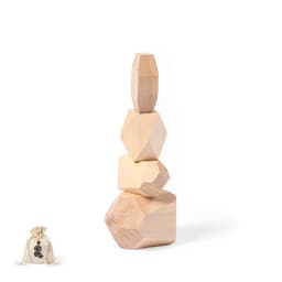 A set of four wooden geometric blocks in natural wood colour, stacked creatively, with a small fabric bag beside them.