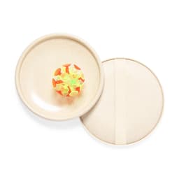 A beige game set with a round, colourful ball featuring vibrant orange and yellow designs, contained in a matching lid.