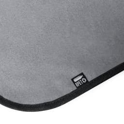 A grey picnic rug with a textured surface and a black border, featuring a small branding tag.
