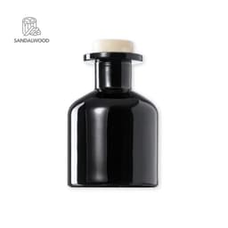 A black aromatic diffuser with a cream-coloured top, featuring a logo design on the left.