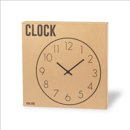 A wall clock in a circular design with black numbers and hands on a brown cardboard packaging.