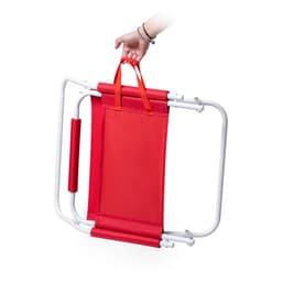 A red folding chair with a white frame is being held by its handles. It features a simple, compact design.