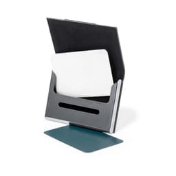 A grey metal business card holder with a black felt backing, displaying a blank white card and a teal card underneath.