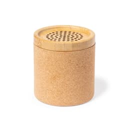 A cylindrical speaker made of cork and bamboo, featuring a perforated top for sound output.