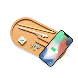 A cork tray with a smartphone charging, a pencil, an eraser, and paper clips in a casual arrangement.