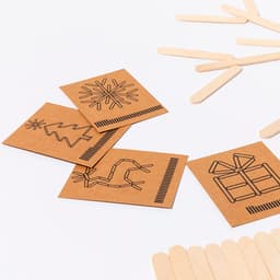 Game cards featuring festive designs on brown cardstock, accompanied by wooden sticks. The colour scheme is brown and natural wood.