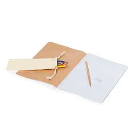 A set of coloured pencils in a natural fabric pouch, alongside a blank notebook and a pencil on a wooden surface.