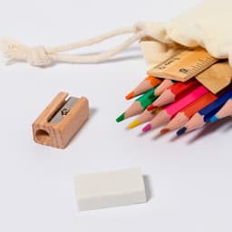 A collection of coloured pencils in various shades, accompanied by a sharpener, eraser, and a canvas pouch.