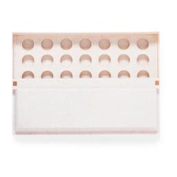 A light-coloured game board with circular compartments, featuring a simple design and a branded logo.