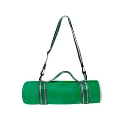 A green picnic rug rolled up with a carrying strap, featuring a logo on the side and contrasting stripes.