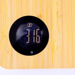 A bamboo chopping board featuring a round digital display with a black casing, showing the number 316.