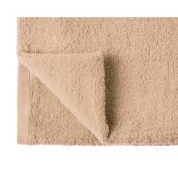 A beige hand towel with a textured surface and a folded corner. Contains a logo.
