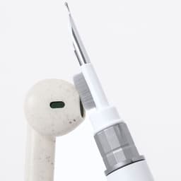 A white pen with a unique design, featuring a brush tip and a metallic grip, alongside an earbud.