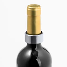 A drink bottle with a black body and a gold cap, featuring a silver Otto Drip Stop Ring around the neck.