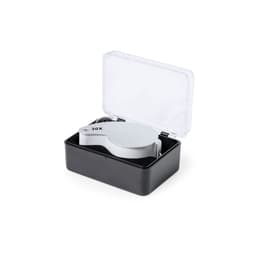 A silver magnifying lens in a black case, with a transparent lid, showcasing its 30X magnification capability.