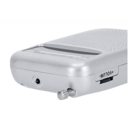 A silver speaker featuring a textured surface, an audio jack, and a volume control knob. It has a logo on the side.