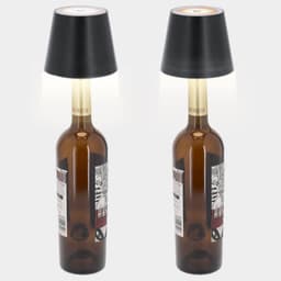 A decorative lamp featuring a black shade and a brown glass bottle base. The design incorporates a logo.